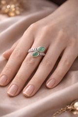 Bague Souffle de Renouveau en argent 925 avec deux pierres aventurine verte sur doigt délicat, design enroulant une bande ornée de petits détails.