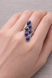 Bague argentée 925 avec pierres bleues lapis-lazuli sur doigt, design étincelant et élégant.