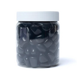 Pillules ou pierres polies en agate noire dans un pot transparent de 1000 g avec bouchon blanc, vue en gros plan