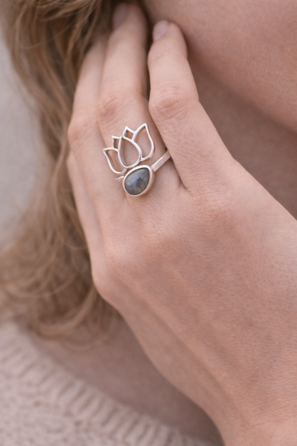 Bague Lotus en argent 925 avec pierre labradorite, portée sur le doigt, design lotus et halo protecteur. Trajectoire d’intuition.