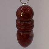 Pendule Egyptien en Jaspe Rouge montre une petite forme cylindrique et arrondie, en jaspe rouge, suspendue par un anneau.